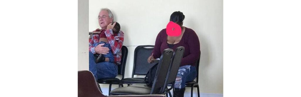 Foto emocionante de um senhor segurando um bebê desconhecido