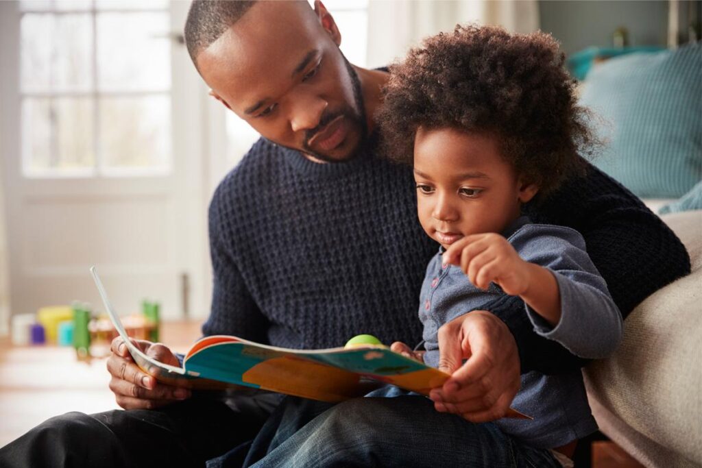 Pai lê para filho em casa