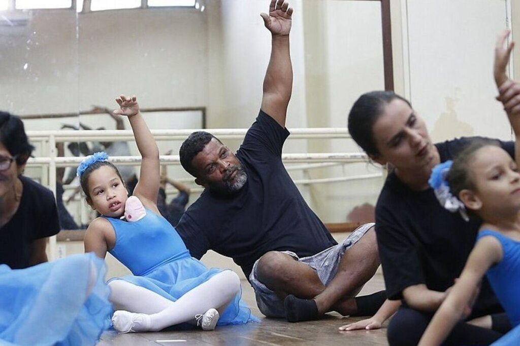 Pai ajuda filha autista na aula de balé