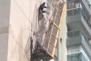 Situação apreensiva! Andaime despenca de prédio com dois homens que ficam pendurados