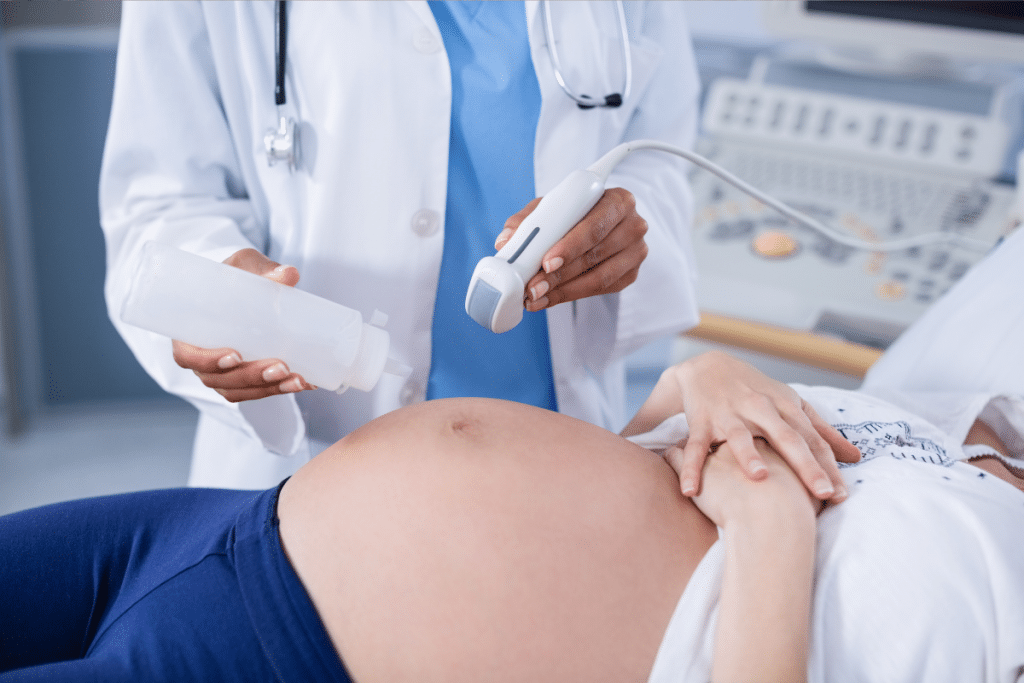 Profissional de saúde exercendo um exame em uma mulher grávida