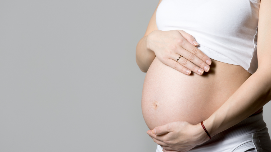 Mulher grávida com a mão na barriga