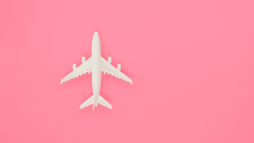 Imagem de uma miniatura de avião em um fundo rosa